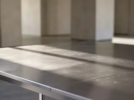 Ein minimalistischer, moderner Arbeitsplatz mit einer gebürsteten Aluminiumoberfläche in sanftem Tageslicht. - Foto: über boerse-global.de