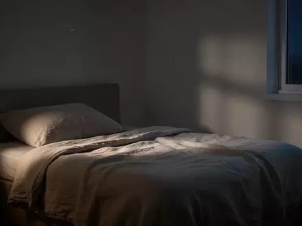 Ein ruhig und minimalistisch eingerichtetes Schlafzimmer bei Nacht mit sanftem Mondlicht. - Foto: über boerse-global.de
