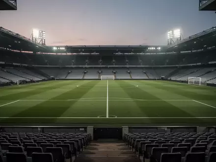 Ein leerer Fußballplatz bei Dämmerung unter Flutlicht, der die angespannte Atmosphäre vor einem Spiel einfängt. - Foto: über boerse-global.de