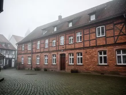 Ein ruhiger, leerer Innenhof neben einem Backsteingebäude in einer deutschen Kleinstadt an einem bewölkten Vormittag. - Foto: über boerse-global.de