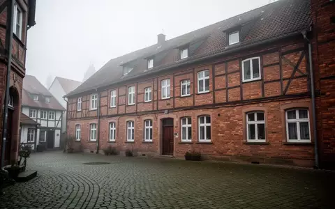 Ein ruhiger, leerer Innenhof neben einem Backsteingebäude in einer deutschen Kleinstadt an einem bewölkten Vormittag. - Foto: über boerse-global.de