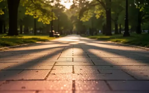 Ein sonnenbeschienener Gehweg in einem Park bei tiefstehender Sonne, der zu sportlicher Betätigung einlädt. - Foto: über boerse-global.de