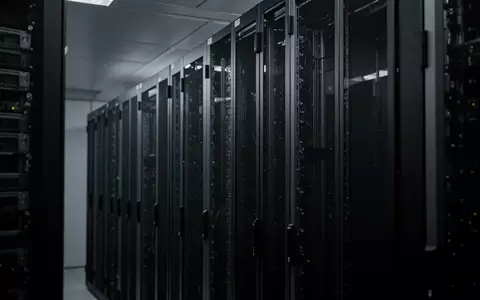 Abstrakte Ansicht von dunklen, geordneten Server-Racks in einem minimalistischen Rechenzentrum. - Foto: über boerse-global.de