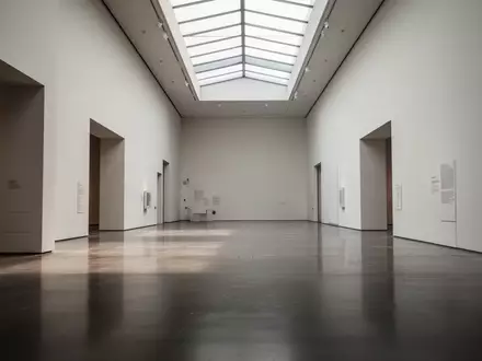 Ein weitläufiger, leerer Museumskorridor mit minimalistischer Architektur und hellem Tageslichteinfall. - Foto: über boerse-global.de