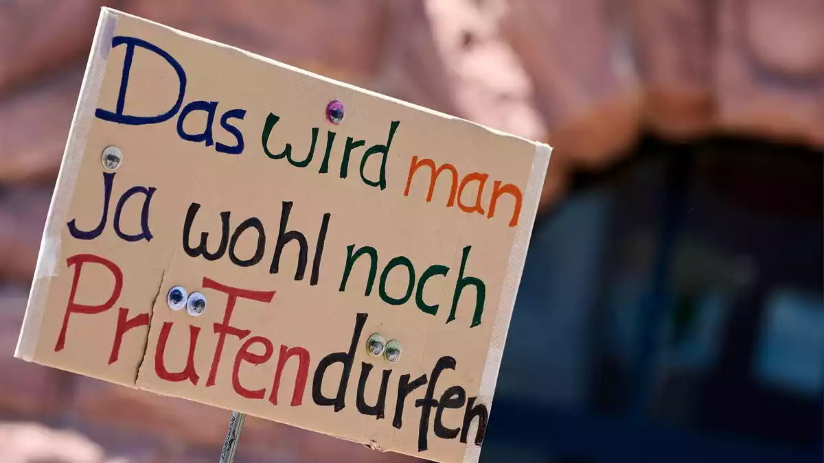 Ein Demonstrant hält ein Protest-Schild bei der Demonstration in Mainz. - Bild: Sascha Ditscher/dpa