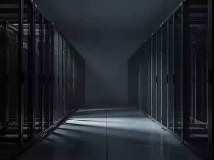 Leerer Serverraum mit dunklen Metallschränken und reflektierendem Boden in einer minimalistischen Umgebung. - Foto: über boerse-global.de