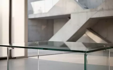 Ein minimalistischer, leerer Schreibtisch in einem hellen, modernen Raum mit architektonischen Linien im Hintergrund. - Foto: über boerse-global.de