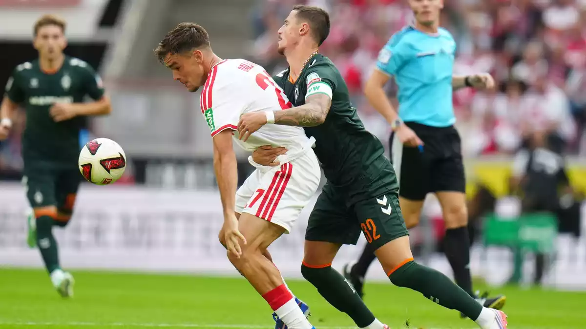 Kölns Thijs Dallinga (l) und Bremens Marco Friedl kämpfen ums den Ball. - Bild: Thomas Frey/dpa