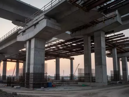 Massive Betonpfeiler und Stahlträger unter einer großen Rheinbrücke bei Dämmerung. - Foto: über boerse-global.de