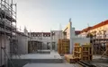 Eine moderne Baustelle mit Betonstrukturen und Gerüsten im Stadtteil Stühlinger bei Sonnenuntergang. - Foto: über boerse-global.de