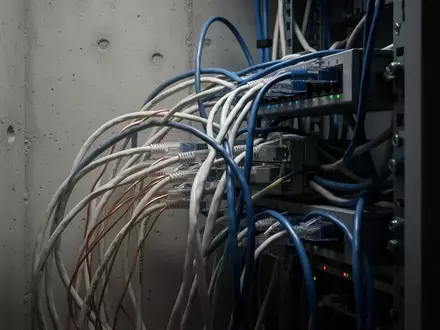 Ein Bündel von Netzwerkkabeln in einem Technikraum zur Veranschaulichung der strukturierten Netzwerkdiagnose. - Foto: über boerse-global.de