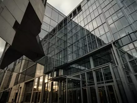 Modernes Regierungsgebäude in Berlin mit architektonischen Glas- und Stahlfassaden unter einem bewölkten Himmel. - Foto: über boerse-global.de