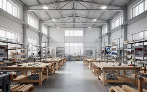 Helle, aufgeräumte Werkstatt mit Werkbänken und Arbeitsgeräten in einem modernen Industriegebäude. - Foto: über boerse-global.de