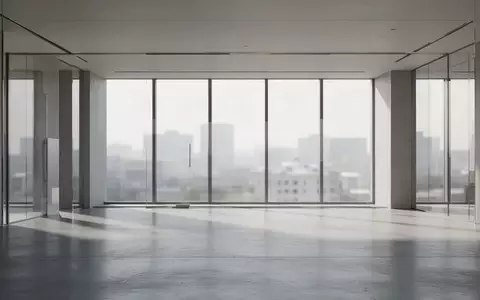 Ein minimalistisches, leeres Bürogebäude mit modernen architektonischen Linien und natürlichem Lichteinfall. - Foto: über boerse-global.de