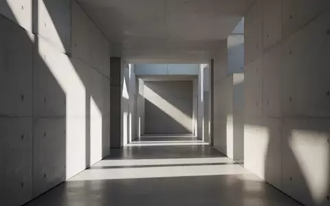 Ein minimalistischer, hell erleuchteter Flur mit geometrischen Schattenwürfen auf glatten Betonwänden. - Foto: über boerse-global.de