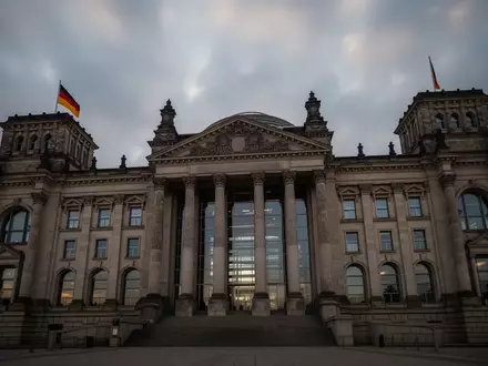 Die imposante Fassade des Reichstagsgebäudes in Berlin unter einem bewölkten Himmel während der Haushaltswoche. - Foto: über boerse-global.de