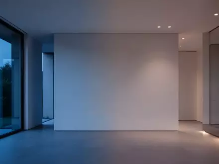 Ein minimalistisches, unmöbliertes Wohnzimmer in der Abenddämmerung, das eine Atmosphäre von Privatsphäre und Schutz vermittelt. - Foto: über boerse-global.de