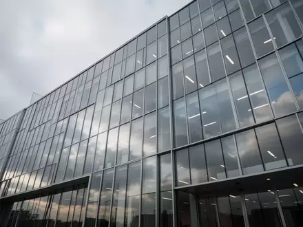 Moderne Glasfassade eines Bürogebäudes bei bewölktem Himmel. - Foto: über boerse-global.de