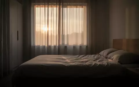Ein minimalistisch eingerichtetes Schlafzimmer in der Morgendämmerung mit weichem, natürlichem Licht. - Foto: über boerse-global.de