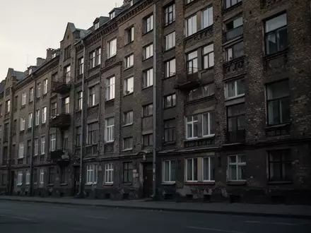Fassade eines dichten Wohngebäudes in einer europäischen Stadt bei Dämmerung mit Fokus auf Fensterreihen. - Foto: über boerse-global.de