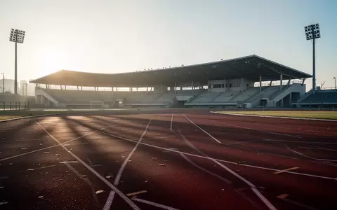 Eine leere Laufbahn in einem Stadion bei Sonnenaufgang, die Ruhe und den Prozess der sportlichen Rehabilitation symbolisiert. - Foto: über boerse-global.de