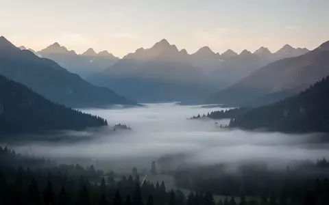 Eine weite, neblige Berglandschaft in der Morgendämmerung, die Ruhe und Besonnenheit ausstrahlt. - Foto: über boerse-global.de