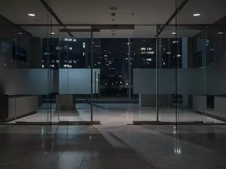 Ein minimalistisch gestalteter, leerer Bankraum bei Nacht mit gedimmter Beleuchtung und klaren architektonischen Linien. - Foto: über boerse-global.de