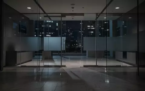 Ein minimalistisch gestalteter, leerer Bankraum bei Nacht mit gedimmter Beleuchtung und klaren architektonischen Linien. - Foto: über boerse-global.de
