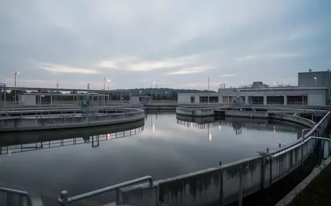Moderne industrielle Kläranlage mit großen Absetzbecken in einer weitläufigen, ruhigen Umgebung bei Dämmerung. - Foto: über boerse-global.de