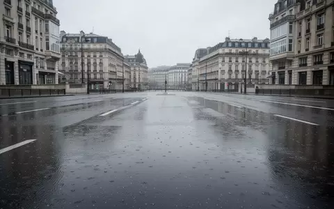 Eine leere, nasse Asphaltstraße in einer städtischen Umgebung unter einem bewölkten Himmel. - Foto: über boerse-global.de