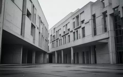 Eine minimalistische, moderne Betonfassade eines deutschen Behördengebäudes an einem bewölkten Tag. - Foto: über boerse-global.de