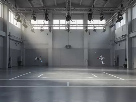 Ein minimalistischer, leerer Trainingsraum mit poliertem Betonboden und markierten Linien für die Robotik-Forschung. - Foto: über boerse-global.de