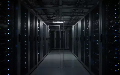 Minimalistische, dunkle Serverraum-Infrastruktur mit blau beleuchteten Racks und industrieller Ästhetik. - Foto: über boerse-global.de