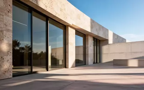 Moderne, minimalistische Fassade eines Gebäudes mit großen Glasfenstern bei Tageslicht. - Foto: über boerse-global.de