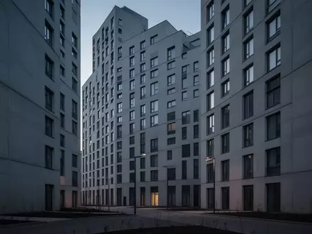 Die Fassade eines modernen, anonymen Studentenwohnheims in der Dämmerung, die durch ihre repetitive Architektur soziale Isolation verdeutlicht. - Foto: über boerse-global.de
