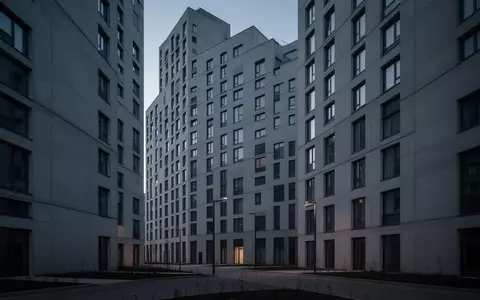 Die Fassade eines modernen, anonymen Studentenwohnheims in der Dämmerung, die durch ihre repetitive Architektur soziale Isolation verdeutlicht. - Foto: über boerse-global.de