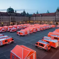 Leeres, nächtliches Übungsgelände mit aufgestellten Rettungszelten und Einsatzfahrzeugen zur Vorbereitung auf Notfälle. - Foto: über boerse-global.de