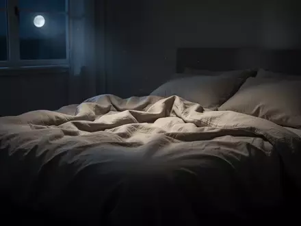 Ein ungemachtes, ruhig beleuchtetes Bett in einem abgedunkelten Schlafzimmer, das eine Atmosphäre tiefer nächtlicher Erholung vermittelt. - Foto: über boerse-global.de