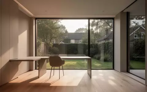 Ein minimalistisch gestalteter, lichtdurchfluteter Arbeitsraum mit weitem Blick in einen Garten. - Foto: über boerse-global.de