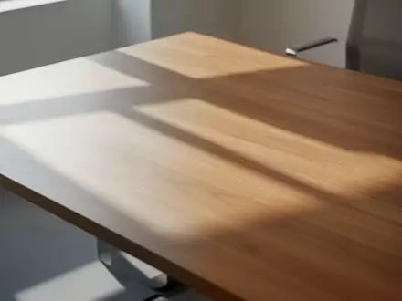 Ein minimalistischer, leerer Schreibtisch mit natürlichem Lichteinfall und geometrischen Schatten. - Foto: über boerse-global.de