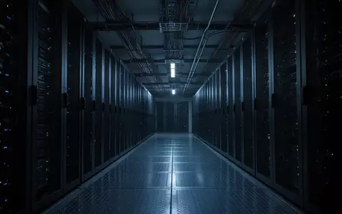 Ein dunkler, modern beleuchteter Serverraum mit metallischen Bodenflächen und Kabelkanälen in einer sterilen Umgebung. - Foto: über boerse-global.de