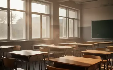 Ein leerer, sonnendurchfluteter Klassenraum mit Holztischen in einem modernen Schulgebäude. - Foto: über boerse-global.de