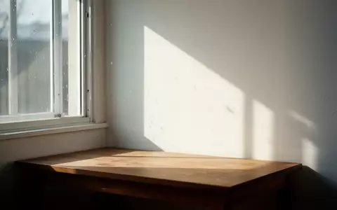 Sanftes Sonnenlicht, das durch ein Fenster auf eine leere Holzoberfläche fällt und Schatten wirft. - Foto: über boerse-global.de