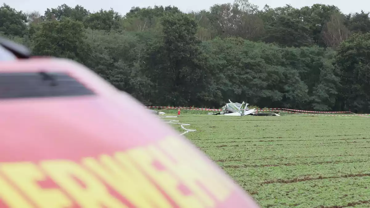 Polizei und Feuerwehr waren am Mittag rund um das Wrack auf einem Feld im Einsatz.  - Bild: -/dpa
