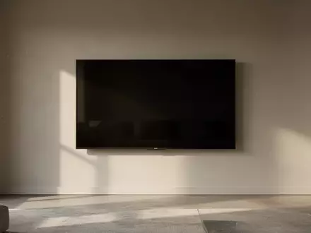 Ein minimalistisches Wohnzimmer mit einem ausgeschalteten, schwarzen Smart-TV an einer schlichten Wand. - Foto: über boerse-global.de