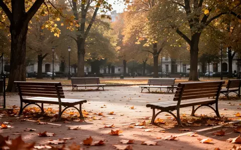 Ein sonniger, leerer Stadtplatz mit Parkbänken und herbstlichen Bäumen in einer ruhigen Atmosphäre. - Foto: über boerse-global.de