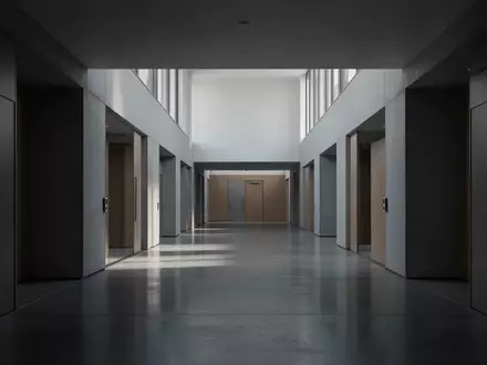 Ein leerer, modern gestalteter Universitätsflur mit klaren architektonischen Linien und natürlichem Lichteinfall. - Foto: über boerse-global.de