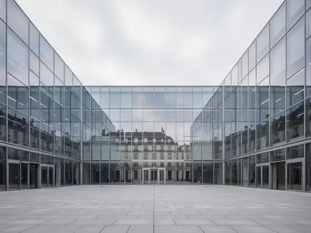 Moderne Glas- und Stahlfassade eines Verwaltungsgebäudes unter bewölktem Himmel. - Foto: über boerse-global.de