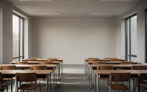 Ein leerer, minimalistischer Klassenraum mit leeren Schreibtischen in einem modernen Schulgebäude bei natürlichem Licht. - Foto: über boerse-global.de