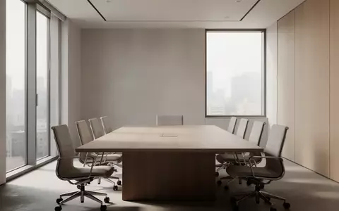Ein minimalistischer, moderner Konferenzraum mit einem leeren Holztisch in einer ruhigen, professionellen Umgebung. - Foto: über boerse-global.de